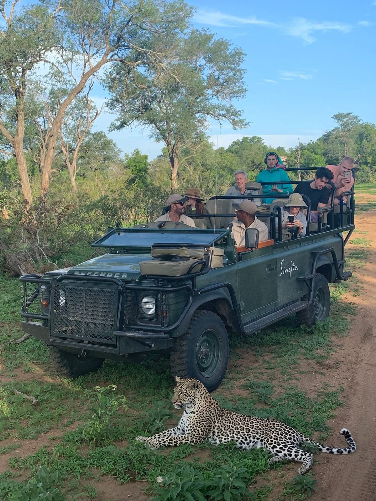 Peter A. Sussman and family on safari, with a leopard beside the vehicle